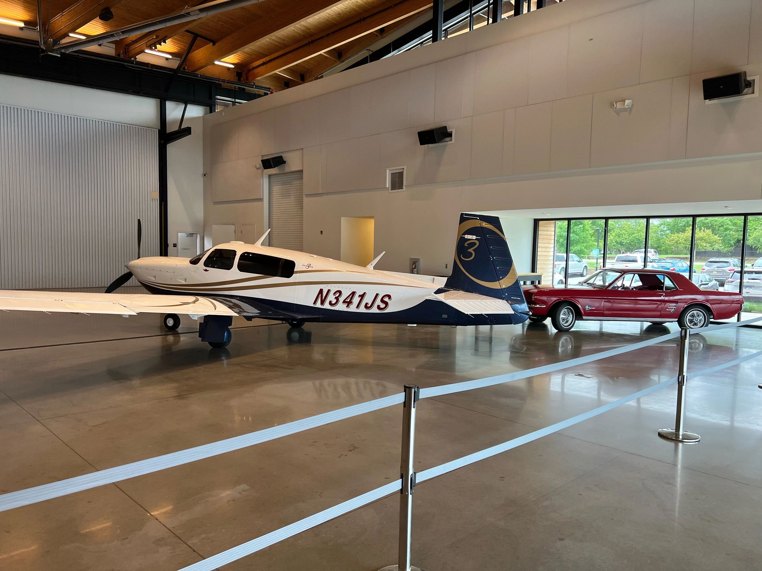 Mooney aircraft alongside a classic Mustang inside the Alpha Company Aviation Sanford Florida hangar