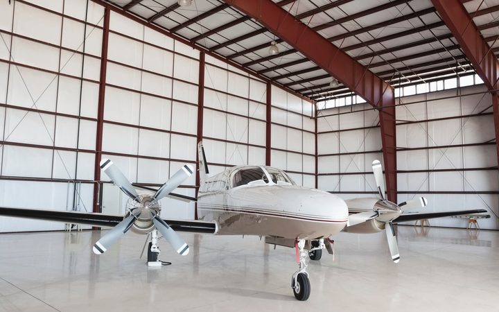 Twin-engine general aviation airplane parked inside a hangar