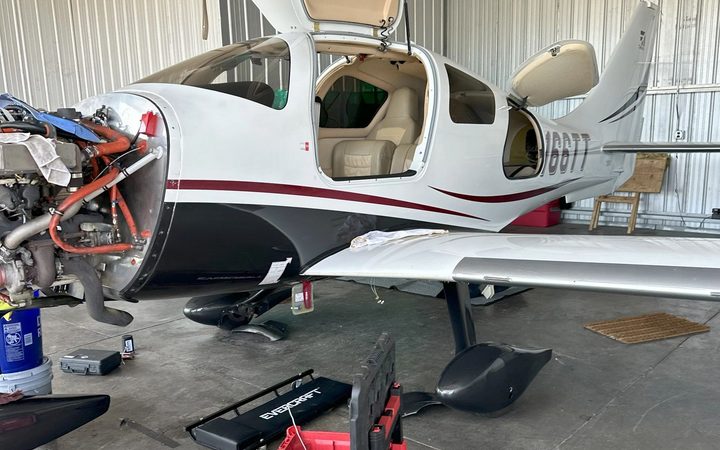 Cirrus with the cowling off and toolboxes alongside during maintenance in the Alpha Company Aviation shop